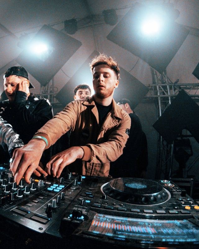 YOUNGS mixe sur une table Pioneer, entouré d’autres artistes